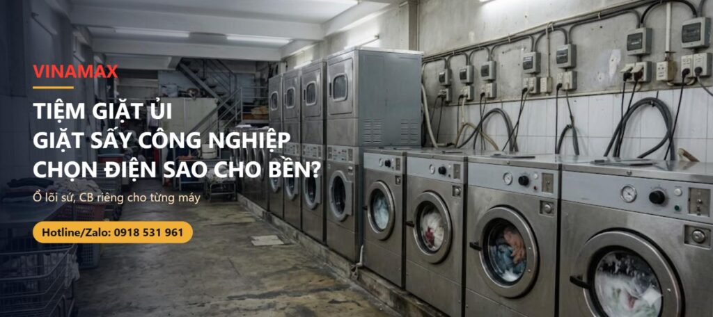 Tiệm giặt ủi công nghiệp với dàn máy giặt máy sấy đang chạy, ổ cắm gắn tường