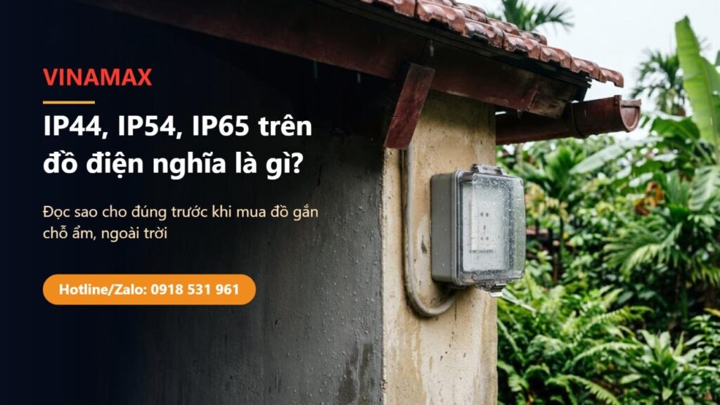 Ổ cắm ngoài trời có hộp che nắp trong suốt gắn trên tường nhà dưới mái hiên, còn đọng nước mưa — minh hoạ chỉ số IP44, IP54, IP65 trên đồ điện